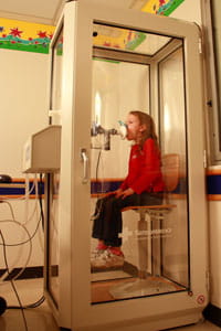 A patient performs a lung volume test while at the Pulmonary Function Laboratory.